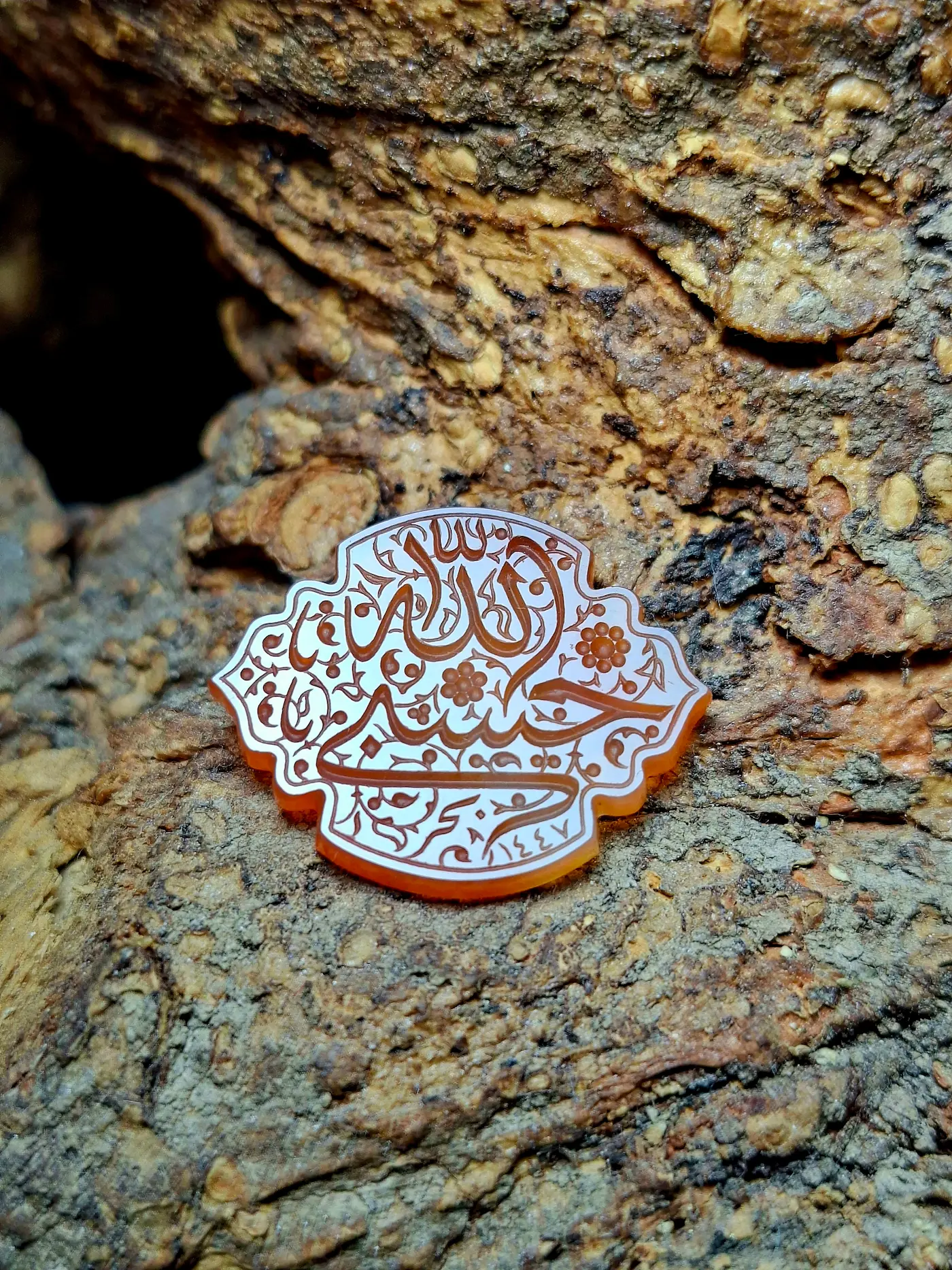 Stone Engraving by Mohsen Karimi. Yellowish stone carved in a cloud like shape with sols writings saying "God is enough for me"